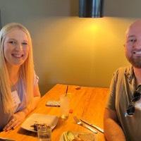 GVSU Alumni smile in booth after eating dinner together